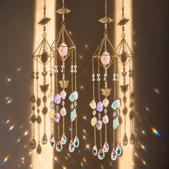 Two gold-toned Cleopatra’s Jewels suncatchers with cascading chains, faceted glass and a mix of Rose Quartz, Clear Quartz, Green Fluorite, Citrine and Amethyst crystals.