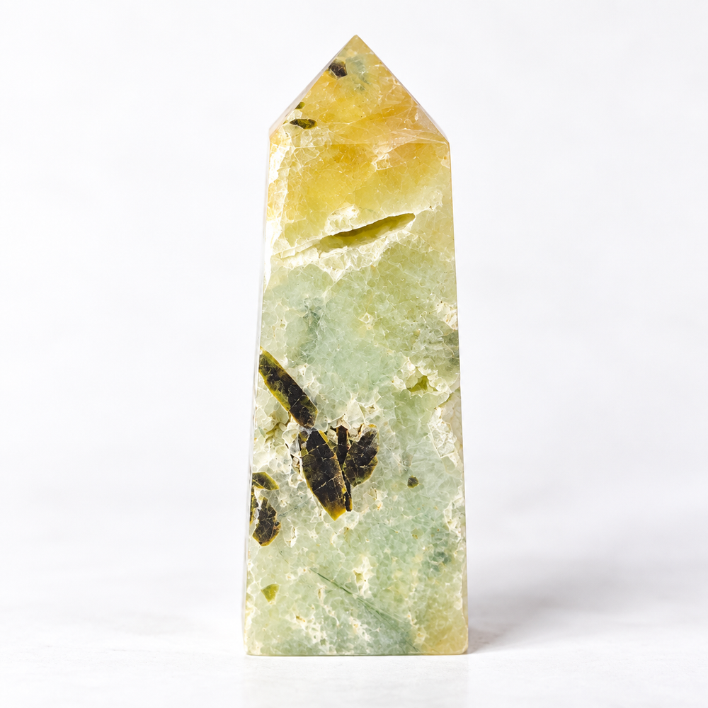A polished natural crystal point, likely a fluorite tower, featuring a marbled pattern of pale green, soft yellow, and dark brown inclusions, set against a seamless white background.