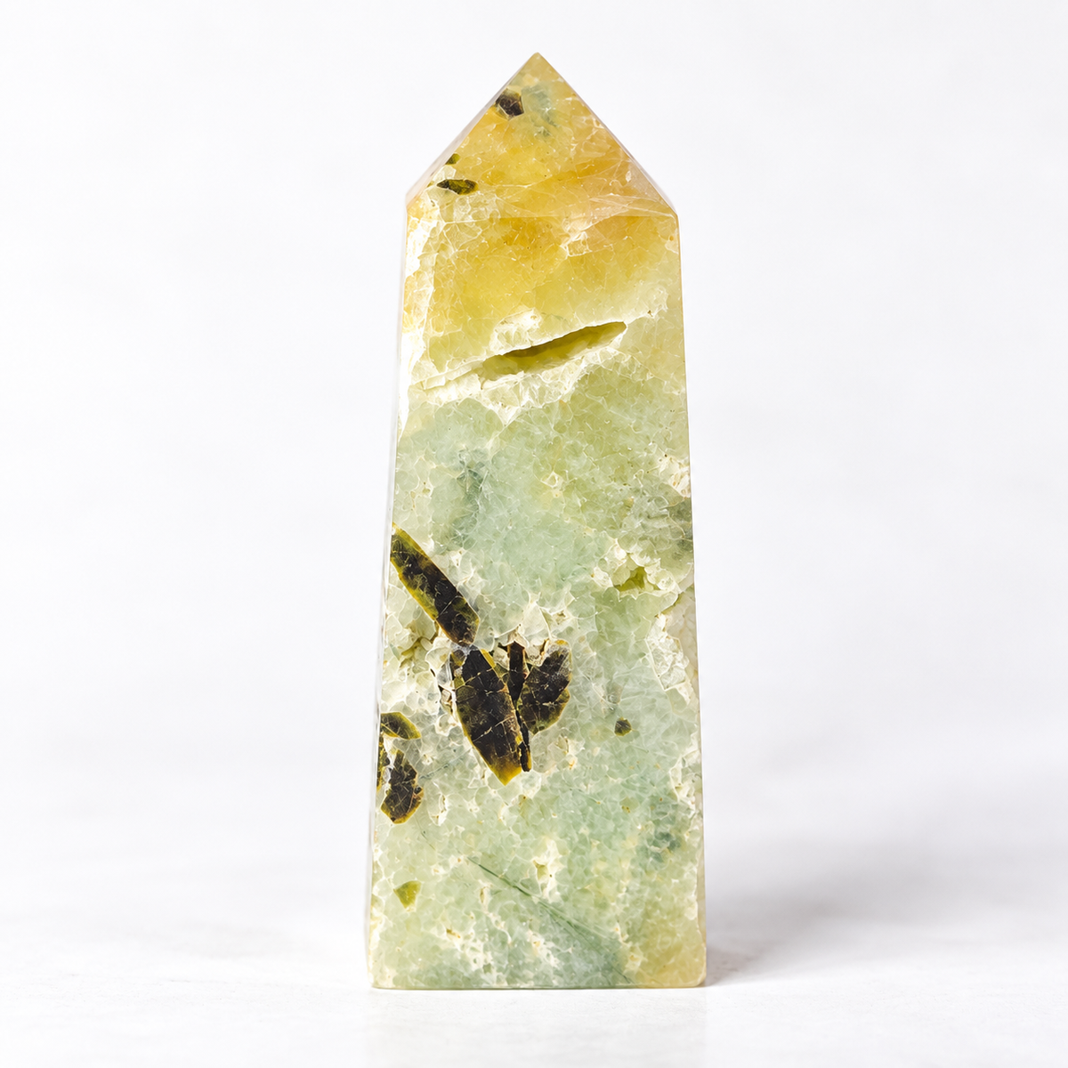 A polished natural crystal point, likely a fluorite tower, featuring a marbled pattern of pale green, soft yellow, and dark brown inclusions, set against a seamless white background.