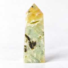 A polished natural crystal point, likely a fluorite tower, featuring a marbled pattern of pale green, soft yellow, and dark brown inclusions, set against a seamless white background.