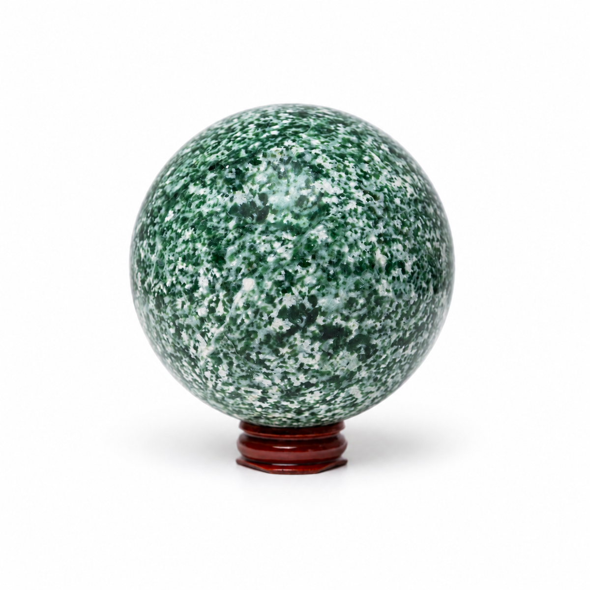 A polished green and white mottled stone sphere displayed on a small reddish-brown wooden stand against a clean white background.