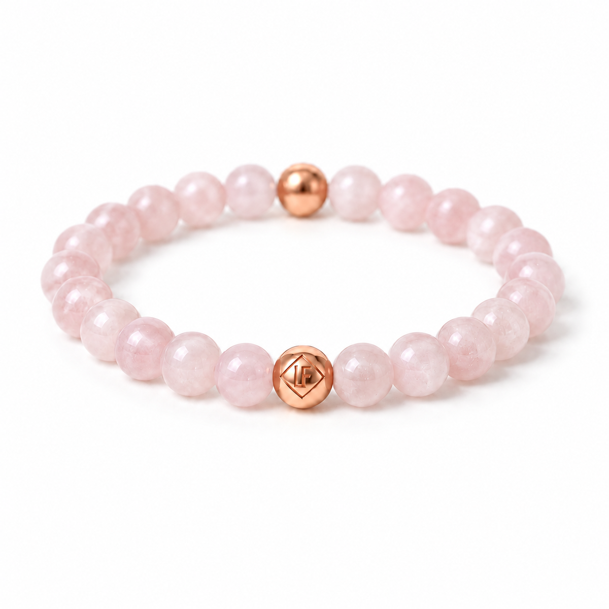 A pink beaded bracelet made of smooth round beads with two rose gold accent beads, one featuring a geometric star design, shown on a clean white background.