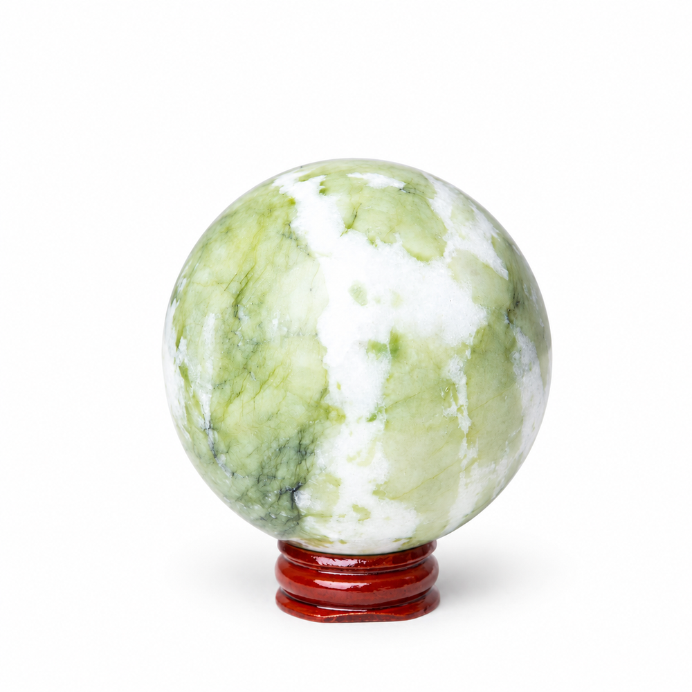 A polished green and white marbled stone sphere resting on a small round reddish-brown wooden stand, photographed against a clean white background.