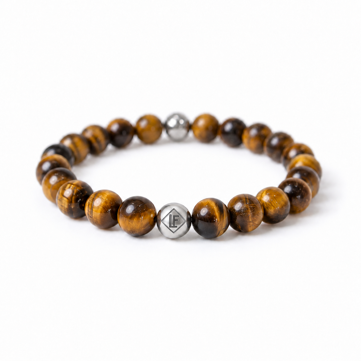 A beaded stretch bracelet featuring round brown and gold tiger's eye beads with two polished silver metal accent beads, one engraved with a geometric logo, on a clean white background.