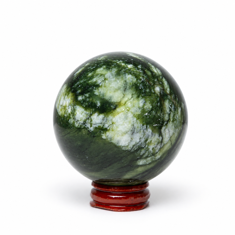 A polished green stone sphere with natural white and dark green marbling, displayed on a small round reddish-brown wooden stand against a plain white background.